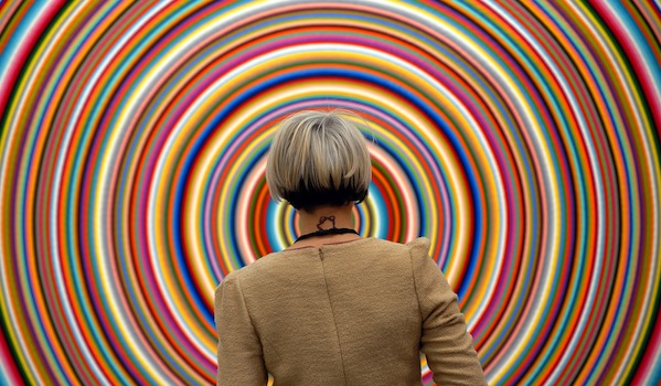 A exhibitor checks a piece of art during