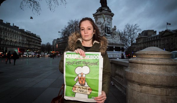 A woman poses with the latest edition of French satirical magazine Charlie Hebdo goes on sale in Paris, France on January 14, 2015. The latest edition of Charlie Hebdo since Islamist attacks on the magazines offices left 12 people dead, has sold out in many parts of France. Three million copies of the controversial magazine have been printed in the wake of last week's terrorist attacks. Photo by Audrey Porey/ABACAPRESS.COM
