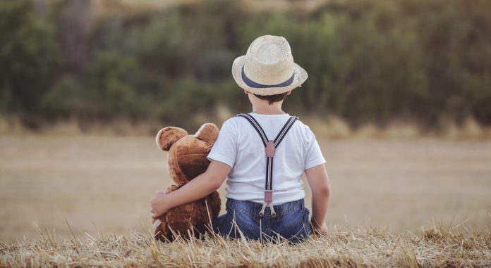 niño abrazado a su oso de peluche