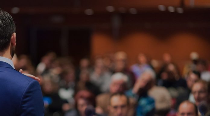 Public speaker giving talk at Business Event.