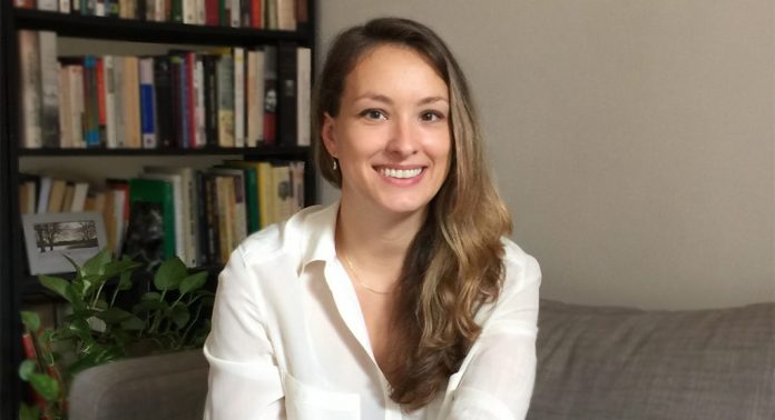 Chloe-Mura-PHD-licensed-psychologist une femme-canapé-bureau-sourire-chemise blanche-psycologue