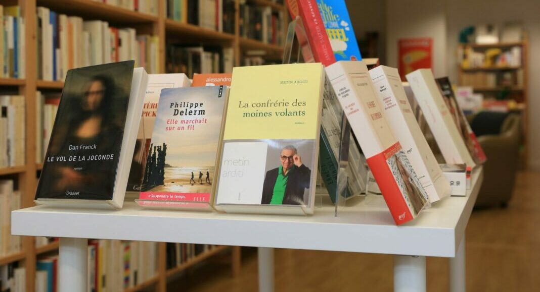 assorted books on white wooden shelf